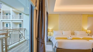 Een hotelkamer met een groot bed, twee nachtkastjes met lampen, een gestuwd hoofdeinde en een balkon met een hekwerk.