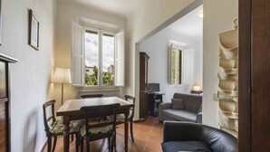 Een eethoek met een houten tafel en stoelen, een bank en een lamp.