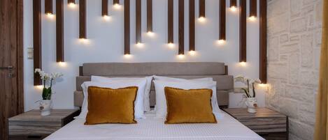 A hotel room with a large bed, wooden slats on the wall, and small lights.