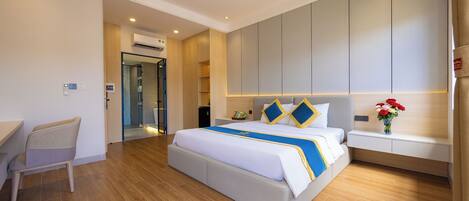 Una habitación de hotel moderna con una cama grande, un escritorio y una zona de estar.