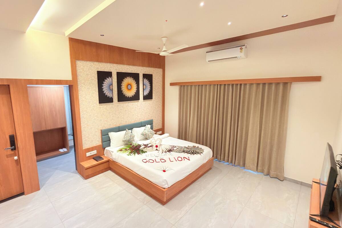 A modern bedroom with a bed, a wardrobe, a ceiling fan, and a wall-mounted air conditioner.