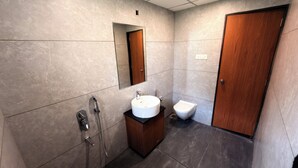 A modern bathroom with a sink, mirror, toilet, and shower. - Gold Lion Resort (Talala)