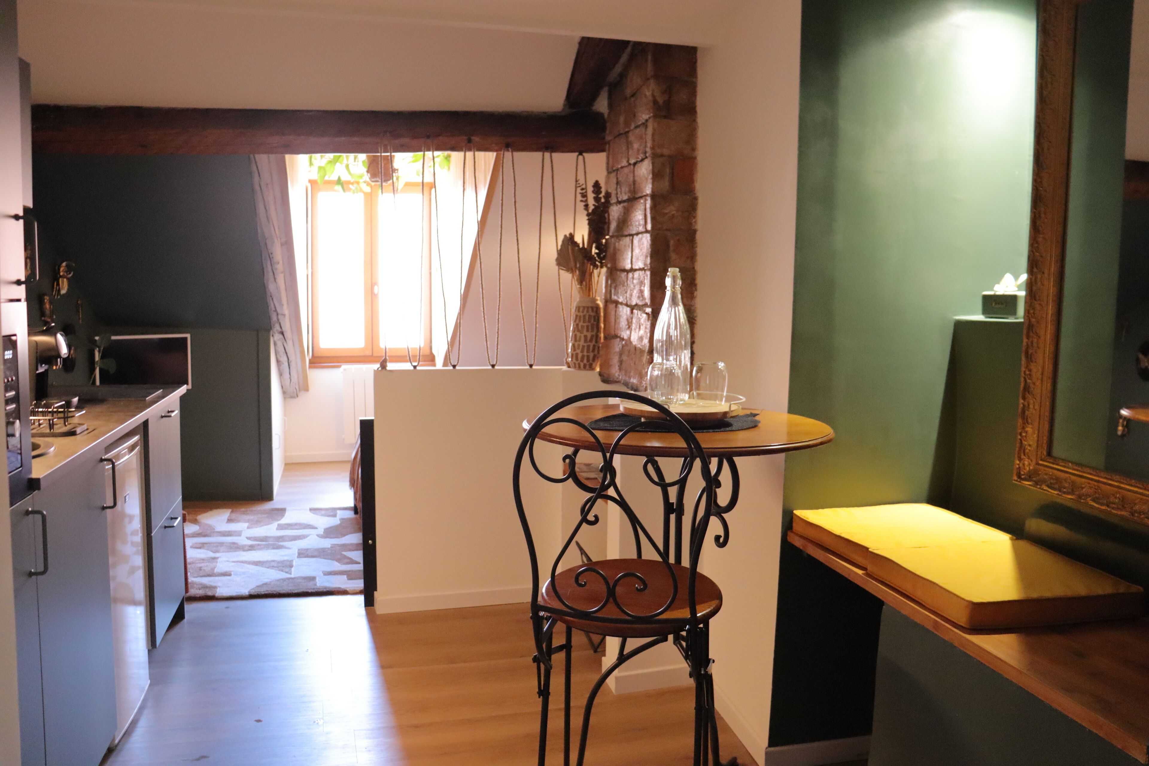 Una cocina con comedor, una mesa de madera y una silla.