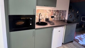 A compact kitchen with a built-in oven, a sink, and a dishwasher.