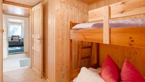A wooden interior with a bunk bed, a door leading to another room, and a visible window. - Bungalow '7 - Finnhütte' with Private Terrace and Shared Garden (Niesky)