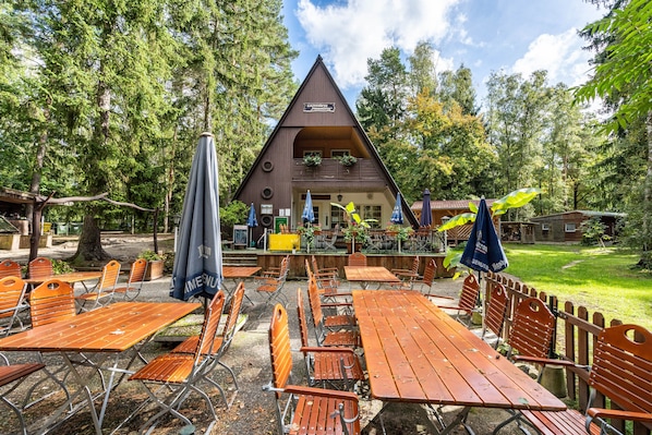 A chalet-style building with outdoor seating and a balcony.
