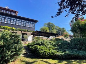 A building with a covered outdoor area, surrounded by dense greenery and trees. - Luxurious villa Floravista for 12 people in Piloña (Valle, Piloña)