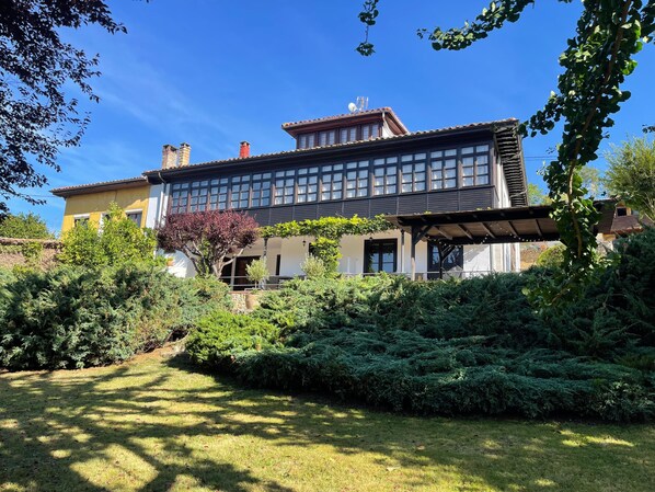 A two-story house with a large garden, a pergola, and a tree with purple leaves. - Luxurious villa Floravista for 12 people in Piloña (Valle, Piloña)