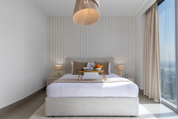 A modern bedroom with a large bed, bedside tables, a bedside lamp, a window with curtains, and a city view. - City Heights Retreat w Panoramic Skyline Views (Dubai)