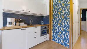 A kitchen with white cabinets, a blue backsplash, and a wooden countertop.