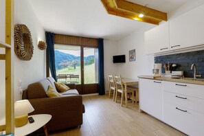 Eine moderne Küche mit weißen Schränken, einer Holzausziehtafel und einem Essbereich mit Tisch und Stühlen.