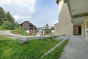 Un quartier résidentiel avec un chemin de gravier, des maisons dotées de balcons et un ciel dégagé.