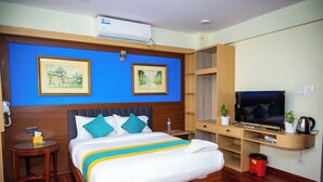 A hotel room with a large bed, a TV, a desk, and two framed pictures on the wall. - Hotel Sara Inn (Kathmandu)