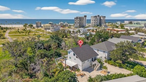 A residential area with a house marked by a red pin, surrounded by greenery and a view of the ocean. - Lower Villa Nature View-Heated Pool/Block to Sand (Fort Myers Beach)