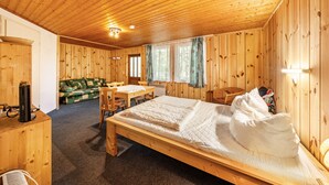 Una baita in legno con un letto, un tavolo e un divano.