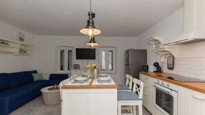 A compact kitchen with a central island, white cabinetry, and a built-in oven.