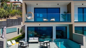 A modern two-story house with a glass balcony, a pool, and outdoor seating. - Villa Nero by LovelyStay (Funchal)