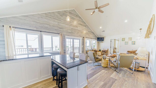 A spacious living area with a kitchen island, a ceiling fan, and a TV mounted on the wall. - 3 Coastal View Houses in 1: Seaview 3BD+ Seasong 2BD* + Selah 4BD (Crescent City)