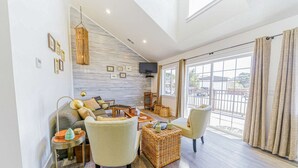 A spacious living room with a sofa, armchairs, a coffee table, and a television mounted on the wall. - 3 Coastal View Houses in 1: Seaview 3BD+ Seasong 2BD* + Selah 4BD (Crescent City)