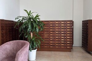 Une pièce comprenant un pot de fleurs, un fauteuil rembourré et une cloison en bois dotée de plusieurs compartiments.