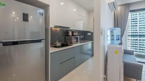 Een moderne keuken met een koelkast, magnetron en waterdispenser.