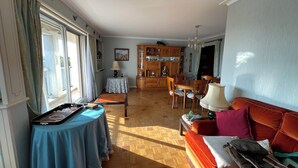 Un vaste salon doté d’un plancher en bois, un coin repas avec une table et des chaises en bois, et une cuisine avec des meubles de rangement en bois.
