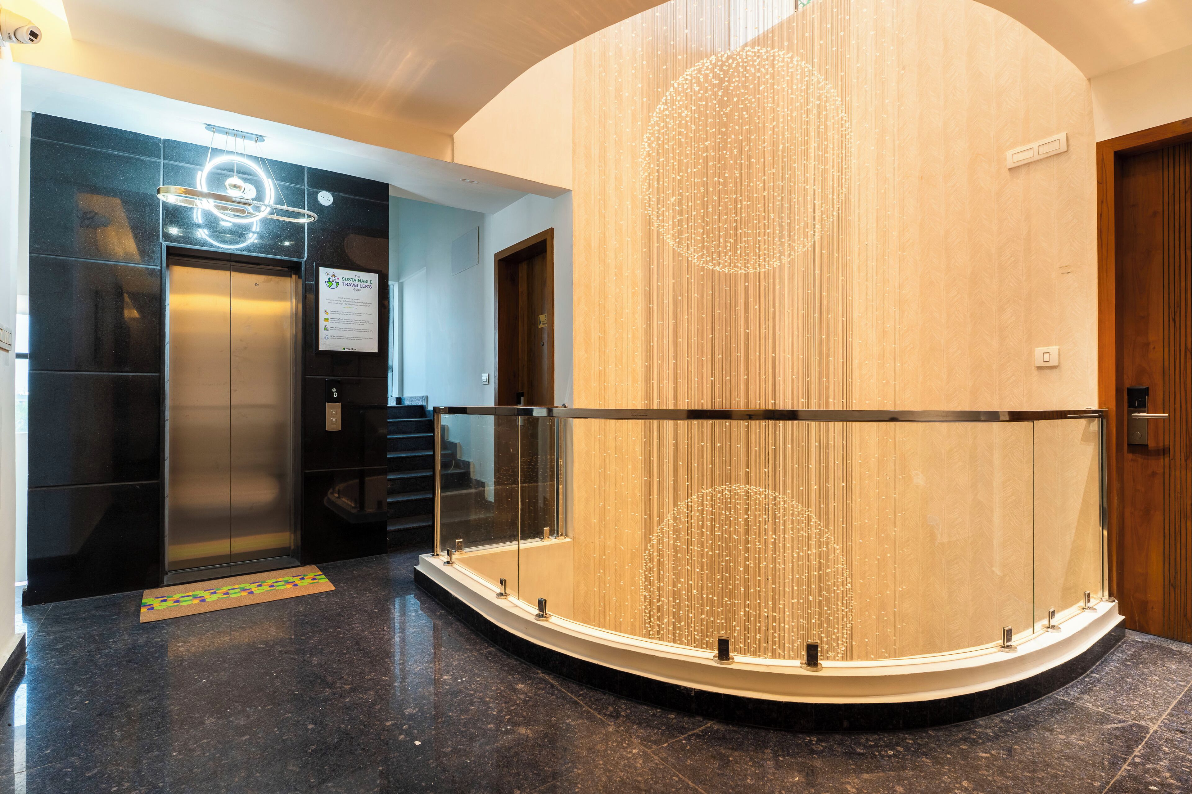 A modern elevator, a glass railing, and a decorative wall feature.
