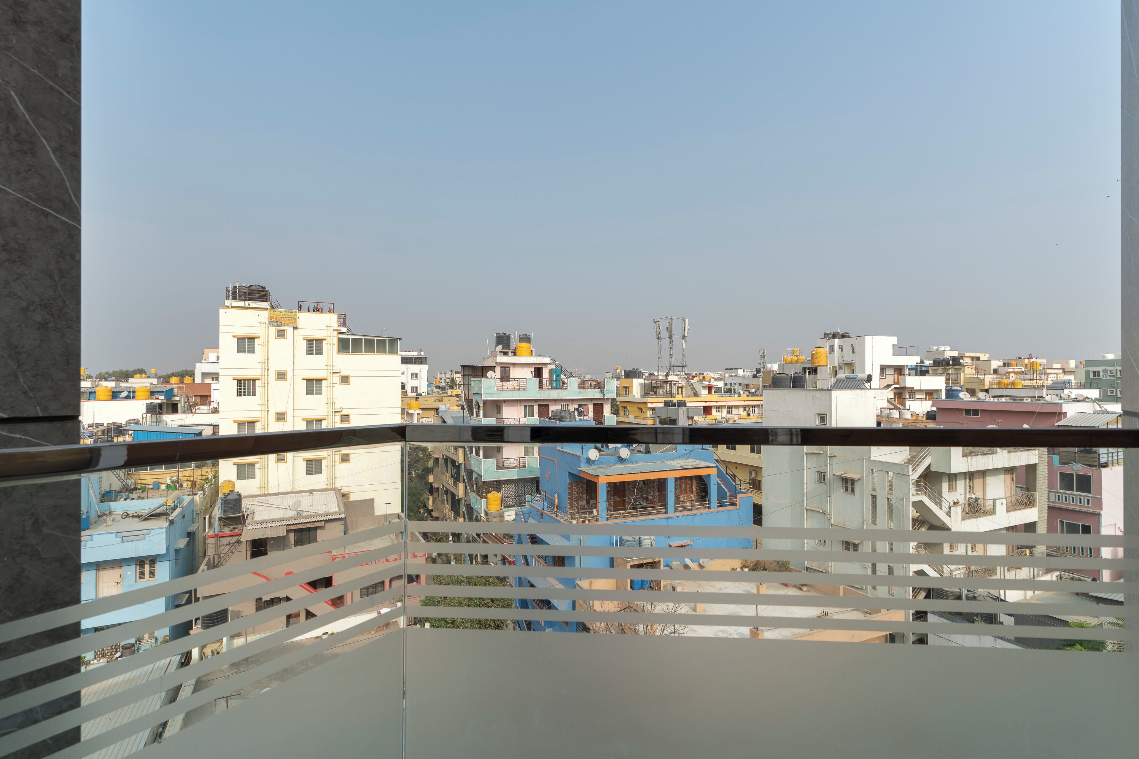 A view of a residential area with multiple buildings, balconies, and a clear sky.