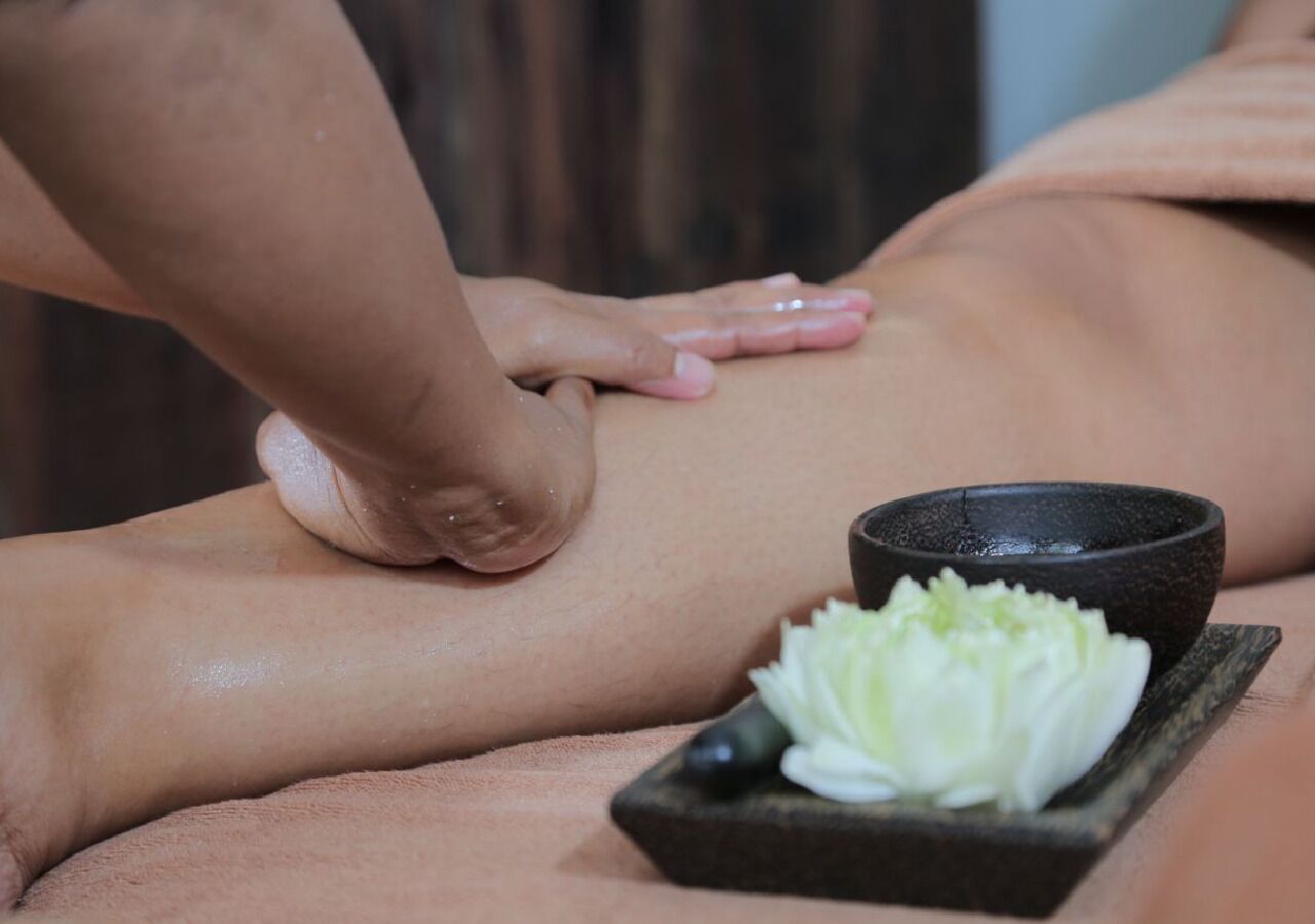 Een massage wordt gegeven, met een schaal vol bloemen op een dienblad.