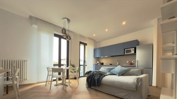 En modern lägenhet med matplats, kök och en soffa.