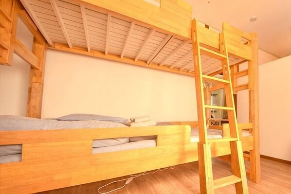 Un letto a castello con una scala, pareti in legno e soffitto bianco.