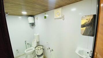 A small, compact bathroom with a toilet, bidet, and sink.