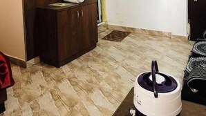 Une pièce comprenant une armoire en bois, un miroir, un lavabo blanc, un ventilateur de plafond, un appareil de climatisation et une fenêtre avec du verre teinté en vert.