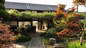 A traditional Japanese building with a tiled roof, a stone pathway, and a garden with various plants and trees. - Tetsu-juro （former Ogunis residence） , Himeji Castles back parlor-like"400-year-old inn" (Fukusaki)