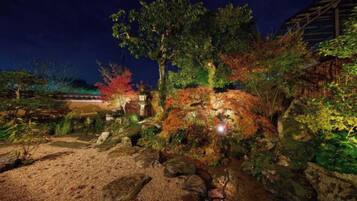 A garden with a pathway, rocks, and various plants.