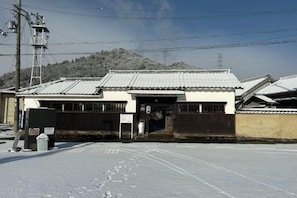 A building with a traditional tiled roof, a gated entrance, and a snow-covered ground. - Tetsu-juro （former Ogunis residence） , Himeji Castles back parlor-like"400-year-old inn" (Fukusaki)