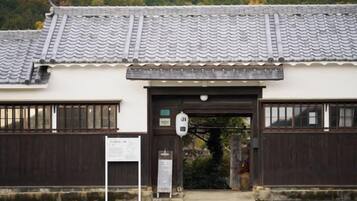 Ein traditionelles japanisches Gebäude mit einem Ziegeldach und einem Holztor.
