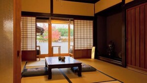 A traditional Japanese room with tatami flooring, a low table, sliding doors, and a view of a garden. - Tetsu-juro （former Ogunis residence） , Himeji Castles back parlor-like"400-year-old inn" (Fukusaki)