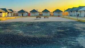 A row of tents with a flat roof and a central walkway. - Stayguru Patgar Tent (Bhuj)