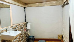 A bathroom with a sink, toilet, and a small stool. - Stayguru Patgar Tent (Bhuj)