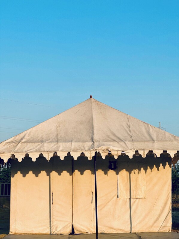 A large, beige tent with a peaked roof and a decorative edge. - Stayguru Patgar Tent (Bhuj)