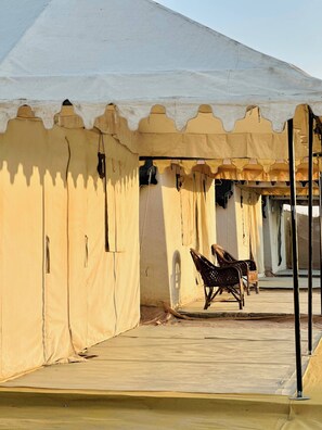 A tented structure with a covered walkway and two wicker chairs. - Stayguru Patgar Tent (Bhuj)