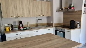 Een moderne keuken met houten kastjes, een roestvrijstalen spoelbak en een ingebouwde oven.