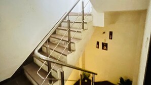 A staircase with metal railings and a handrail, leading to an upper floor. - Roomshala Hotel Jagannath (New Delhi)