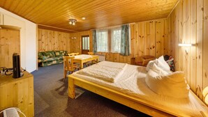 Una cabaña de madera con una cama individual, una mesita, un sofá y un escritorio.