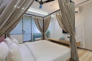 Una habitación de hotel moderna con una cama grande, un ventilador de techo, un televisor y una pared de mármol.
