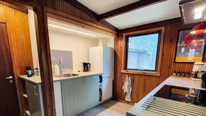 A compact kitchen with a built-in sink, a refrigerator, and a window. - 4 Star Holiday Home in Ry (Ry)