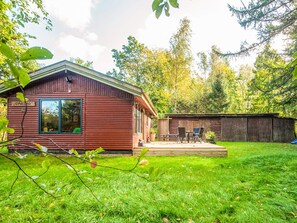 A cabin with a deck, a covered outdoor seating area, and a fenced yard. - 4 Star Holiday Home in Ry (Ry)