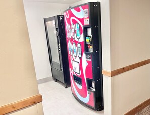 Un distributeur automatique au design coloré, doté d’une porte et d’un panneau indiquant qu’il accepte les cartes de crédit et de débit.