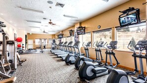A gym with treadmills, weight machines, and exercise balls.